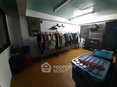 Spacious storage room with clothing racks and ample lighting