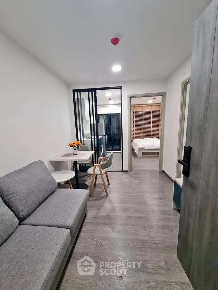 Modern apartment interior with cozy living room and bedroom view, featuring sleek furniture and stylish decor.