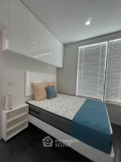 Modern bedroom with sleek white cabinetry and cozy bed setup