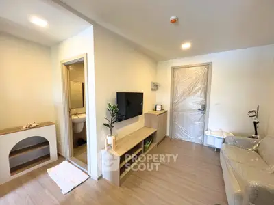Modern living room with sleek furniture and wall-mounted TV in a cozy apartment.