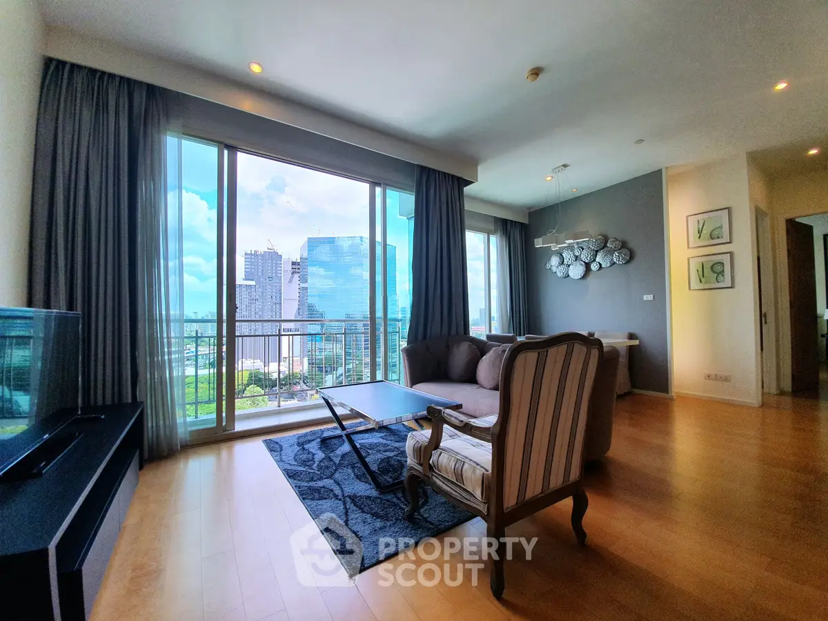 Spacious living room with floor-to-ceiling windows offering stunning city views, elegant furniture, and modern decor.