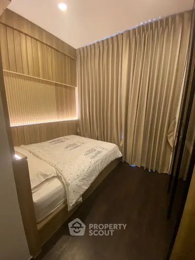 Cozy bedroom with elegant wooden paneling and soft lighting, featuring luxurious curtains and a comfortable bed.