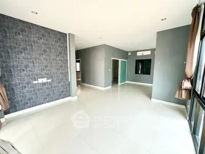 Spacious modern living room with elegant tile flooring and stylish accent wall