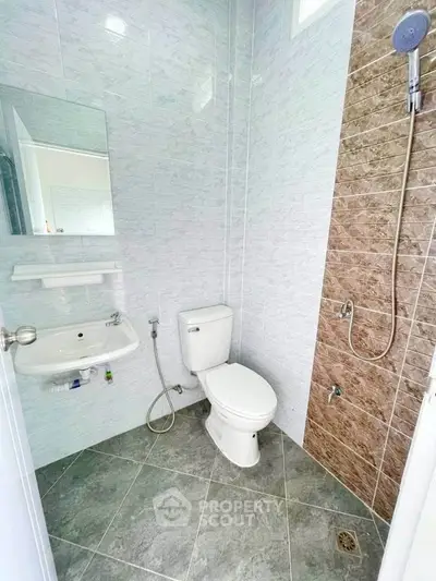 Modern bathroom with sleek tiles and shower in real estate property