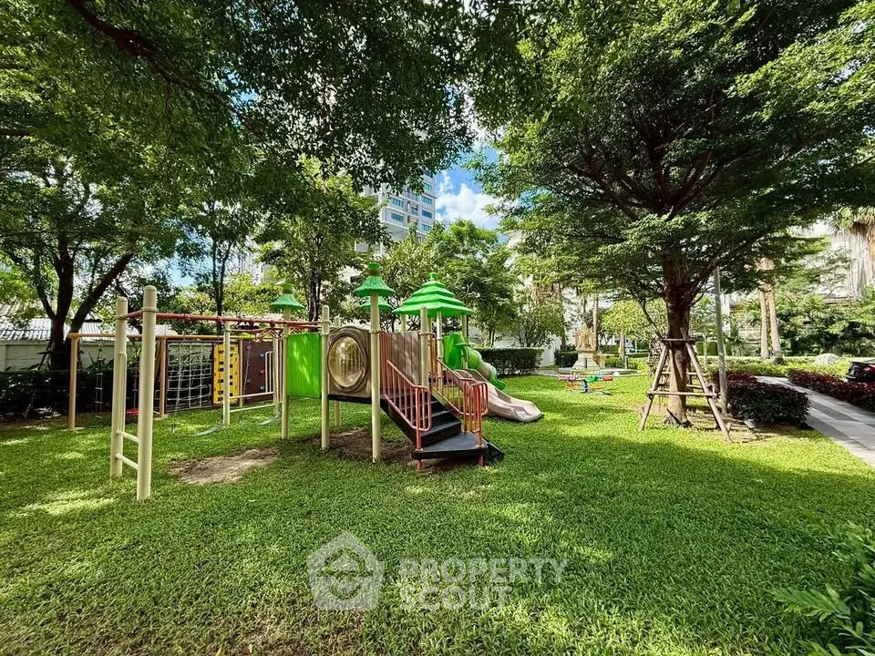Spacious garden with playground in a residential complex, ideal for family living.