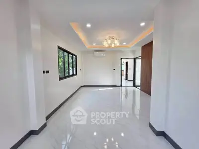 Spacious modern living room with elegant lighting and large windows in a contemporary home.