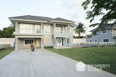 Stunning two-story modern home with spacious driveway and lush green lawn.