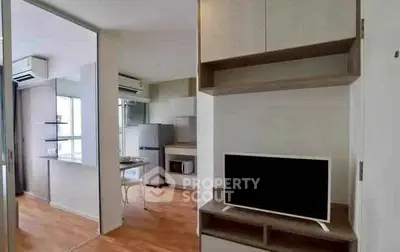 Modern apartment interior with open kitchen and living area, featuring sleek appliances and wooden flooring.
