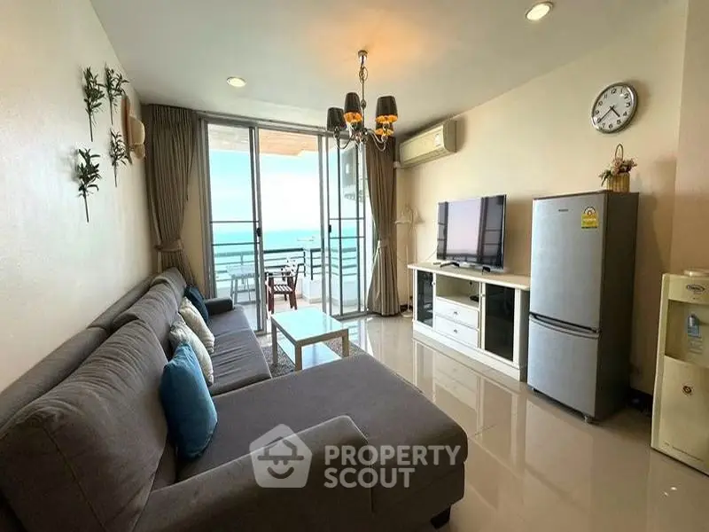 Spacious living room with ocean view, modern furniture, and balcony access in a luxury apartment.