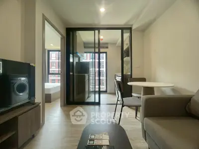 Modern apartment interior with open layout, featuring a cozy living area and a compact kitchen.
