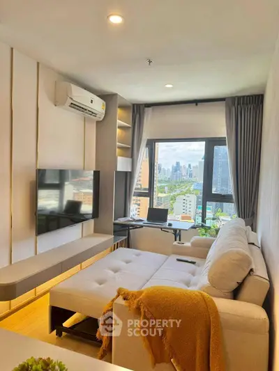 Modern living room with city view, featuring a cozy sofa and wall-mounted TV.