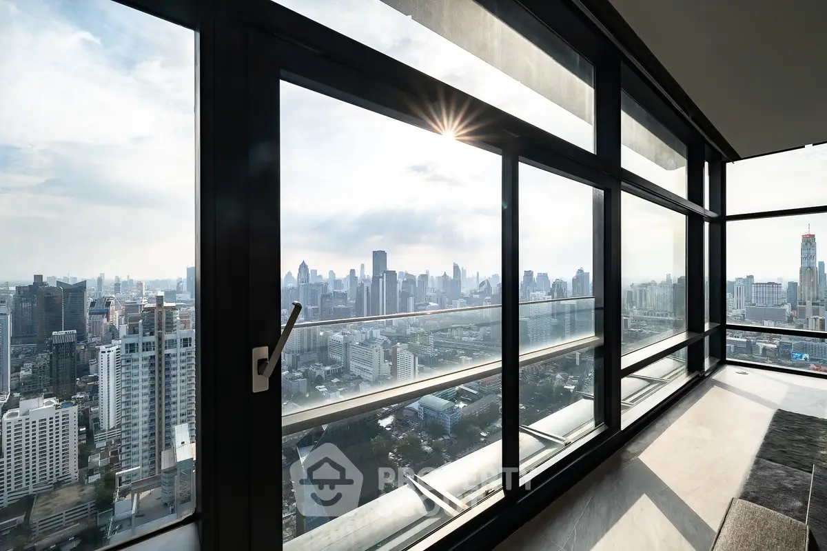 Stunning high-rise apartment with panoramic city skyline views through large windows.