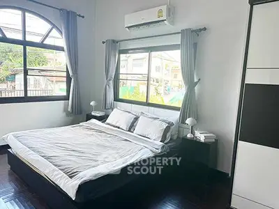 Spacious bedroom with large windows and modern furnishings