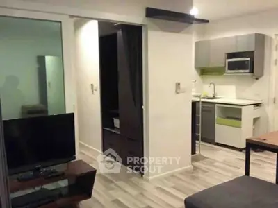 Modern apartment interior with open kitchen and living area, featuring sleek design and contemporary furnishings.