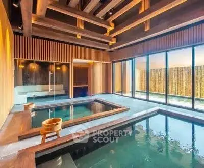 Luxurious indoor pool area with wooden accents and large windows offering serene views.