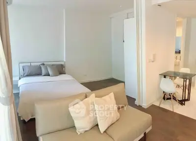 Modern studio apartment with cozy bed and stylish seating area