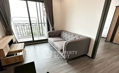 Modern living room with cozy gray sofa and balcony view in a stylish apartment.