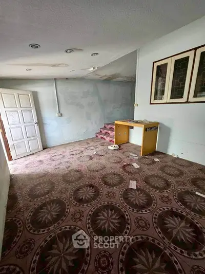 Spacious room with vintage carpet and unique decor, ideal for renovation opportunities.