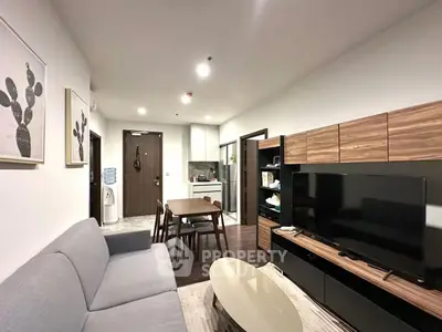Modern living room with stylish furniture and open kitchen layout in a cozy apartment.