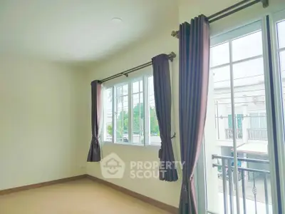 Bright and airy room with large windows and elegant curtains, perfect for a cozy living space.