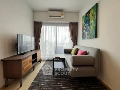 Modern living room with stylish sofa, TV, and large window offering city views.