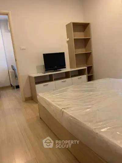 Cozy bedroom with modern furniture and TV, perfect for relaxation.