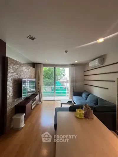 Spacious living room with modern decor and large windows offering natural light and garden view.