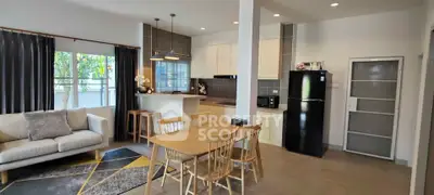 Modern open-layout living room and kitchen with stylish decor and natural light.
