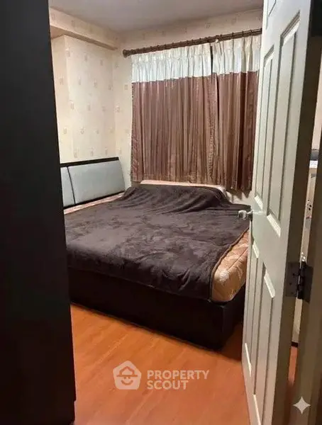 Cozy bedroom with wooden flooring and large bed, perfect for relaxation.