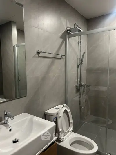 Modern bathroom with sleek shower and elegant fixtures in contemporary apartment.