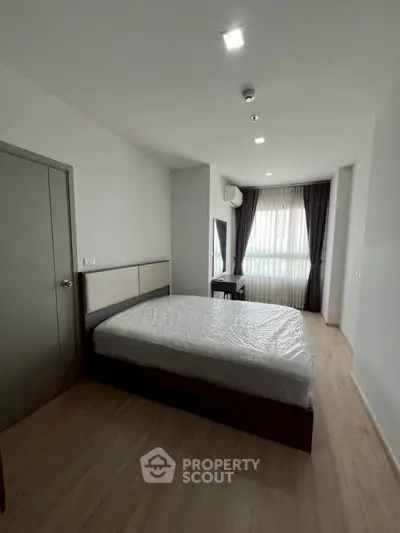 Spacious bedroom with modern design and natural light in a stylish apartment.