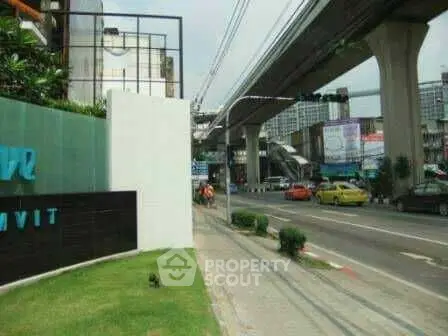 Urban street view with elevated train tracks and nearby buildings, showcasing city infrastructure.