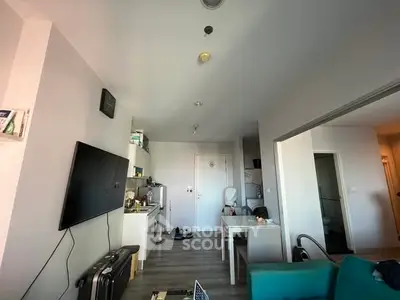 Modern living room with wall-mounted TV and dining area in open layout apartment.