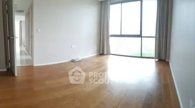 Spacious empty room with large window and wooden flooring, perfect for customization.