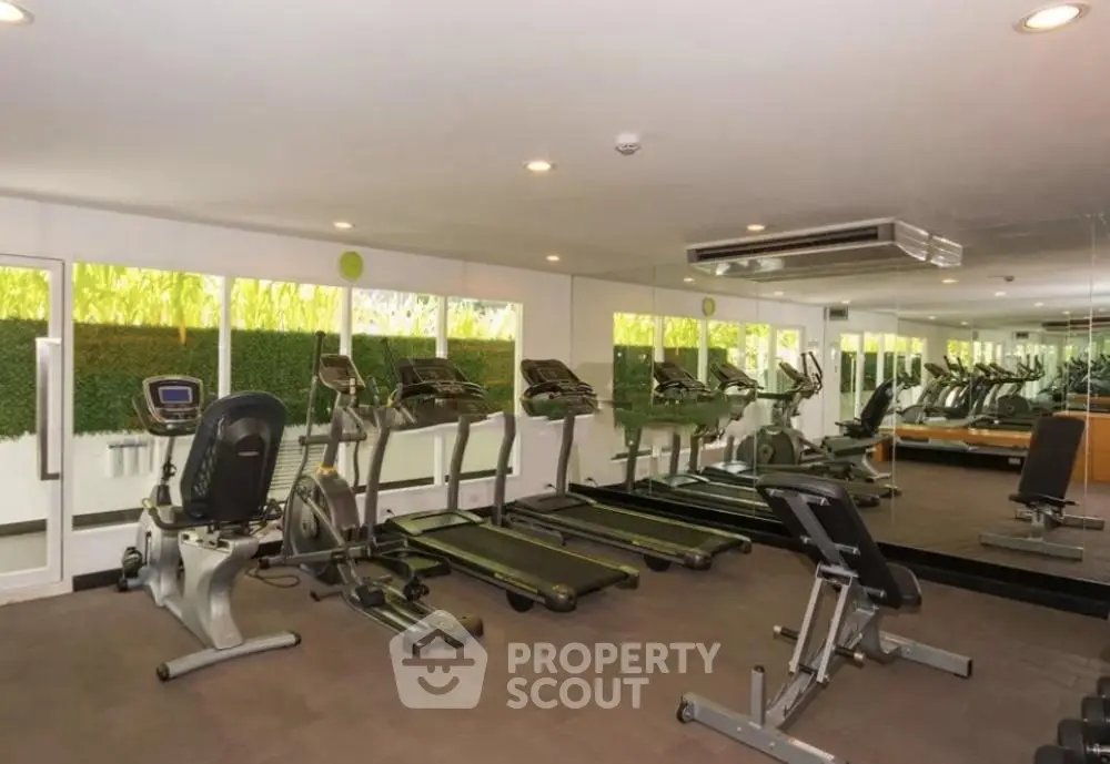 Modern gym with state-of-the-art fitness equipment and mirrored walls in a luxury apartment complex.