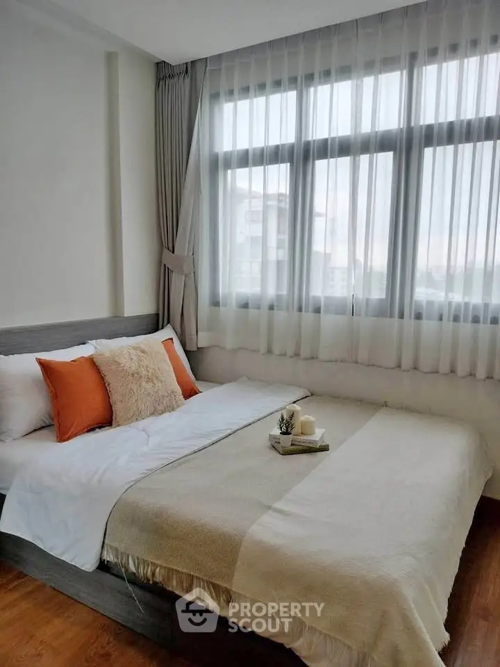 Cozy bedroom with large window and stylish decor in modern apartment