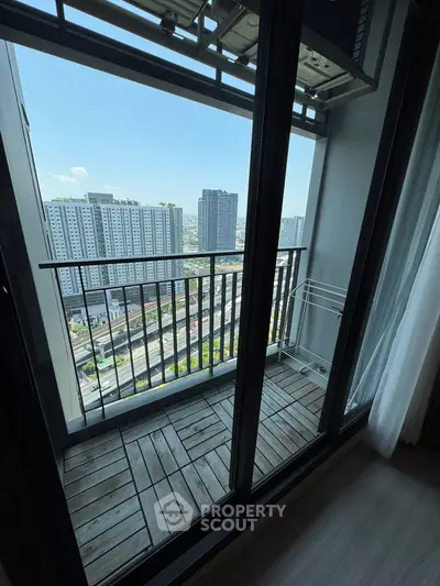 Modern apartment balcony with city view and wooden flooring, perfect for urban living.