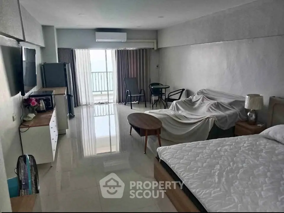 Spacious studio apartment with modern furnishings and balcony view