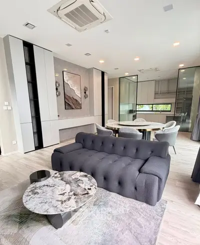 Modern living room with stylish furniture and open kitchen layout in a luxury apartment.