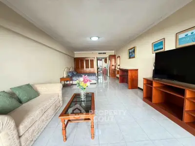 Spacious living room with modern furniture and large TV, perfect for relaxation.