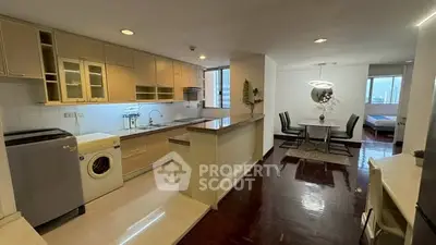 Spacious open-layout kitchen with modern appliances and dining area in a stylish apartment.