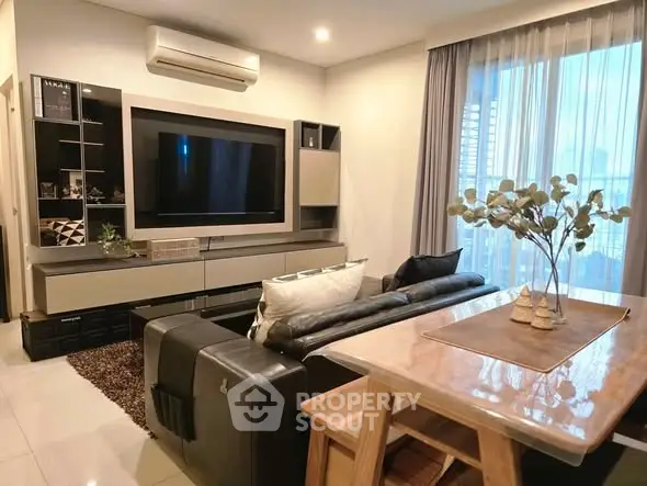 Modern living room with sleek furniture and large TV, perfect for relaxation.