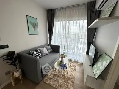 Chic modern living room with cozy sofa, stylish decor, and large window for natural light.