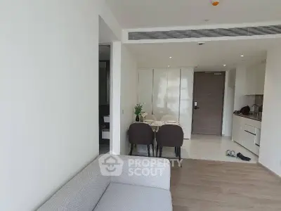Modern open-plan living room with dining area and kitchen in a stylish apartment.