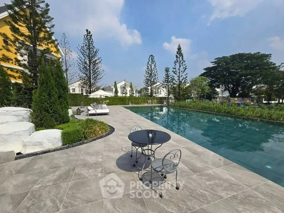 Luxurious outdoor pool area with elegant seating and lush greenery