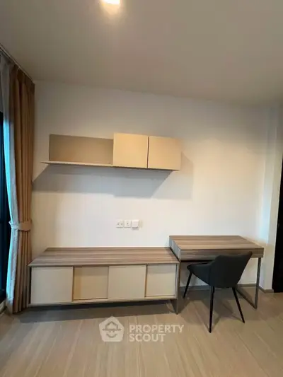 Modern study room with sleek desk and chair, wall-mounted shelves, and elegant wood flooring.