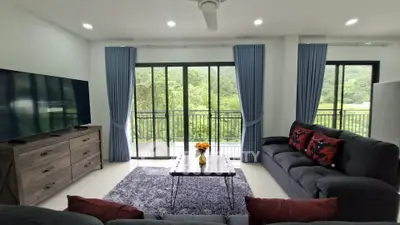 Spacious living room with large windows and scenic balcony view