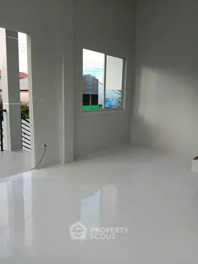 Spacious modern interior with glossy white floors and balcony access, perfect for customization.