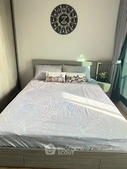 Cozy bedroom with stylish decor and natural light, featuring a comfortable bed and elegant wall clock.