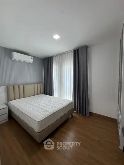 Spacious bedroom with modern design, featuring a large bed and elegant curtains.